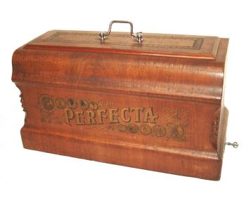 Abdeckhaube mit Perfecta Schriftzug <br />und den 10 Medaillen der Weltausstellungen. 
